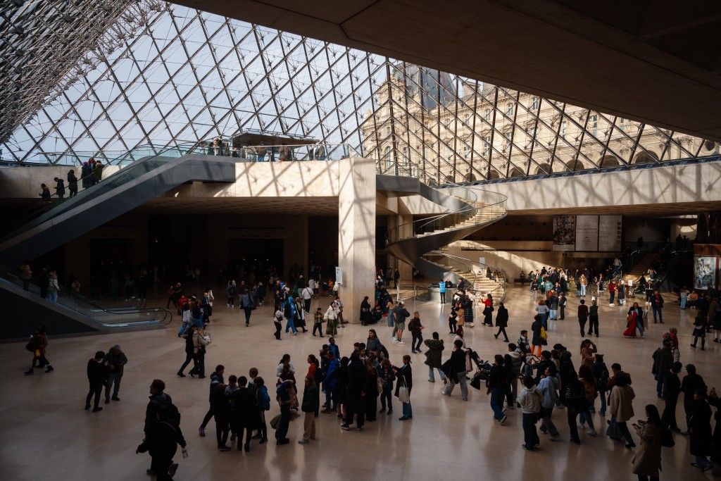 Visitors walk under the Louvre Pyramid designed by Ieoh Ming Pei at the Louvre Museum in Paris on January 23, 2025. (AFP)