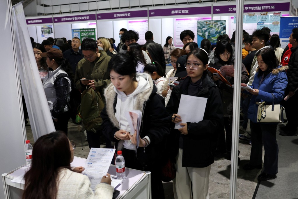 A recruiter attends to an applicant at a job fair in Beijing, China March 14, 2026. REUTERS/Florence Lo