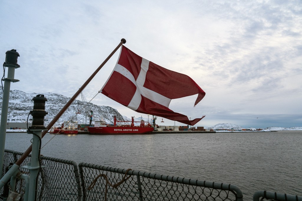 Photo by ALESSANDRO RAMPAZZO / AFP. The Danish flag flies form the deck of the HDMS Knud Rasmussen Royal Danish Navy patrol vessel, moored at the harbour in Nuuk, Greenland on January 16, 2026.