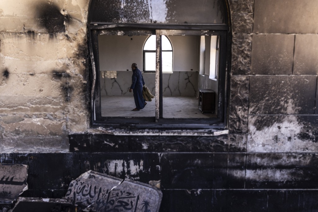 Photo by JOHN WESSELS / AFP  A Palestinian man prepares to pray at a mosque allegedly burned by Israeli settlers in the village of Qusra, south of Nablus in the Israeli-occupied West Bank on July 26, 2026.