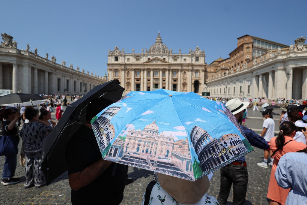 Faithful shield themselves with umbrellas amid a heatwave as they wait for Pope Leo to lead the Angelus prayer from a window of the Apostolic Palace, in St. Peter's Square, at the Vatican, June 29 (Reuters)