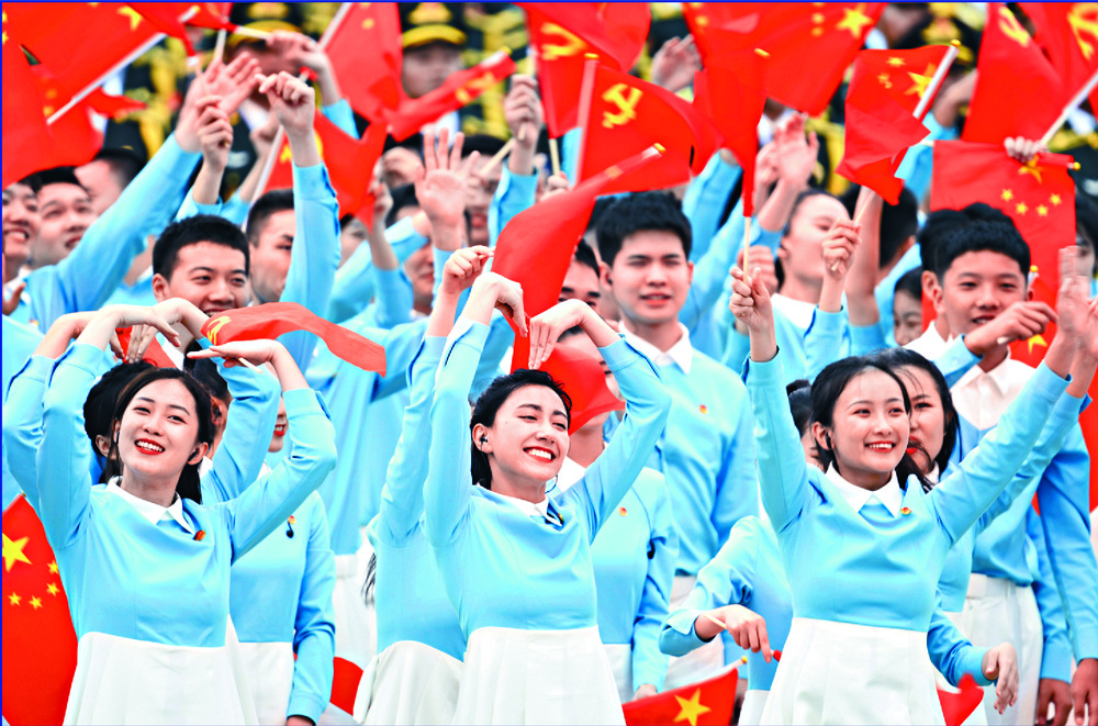 Performers dance as soldiers fire a 100-gun salute. XINHUA