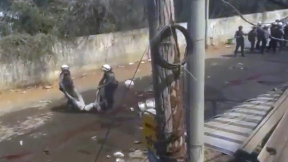 In this March 3, 2021 image from video obtained by The Associated Press, police carry the body of someone who witnesses say was shot by security forces in Monywa, Myanmar. Since the military seized control of Myanmar in a takeover on Feb. 1, more than 825 people have been killed _ well over two times the official tally _ according to watchdog group Assistance Association for Political Prisoners.