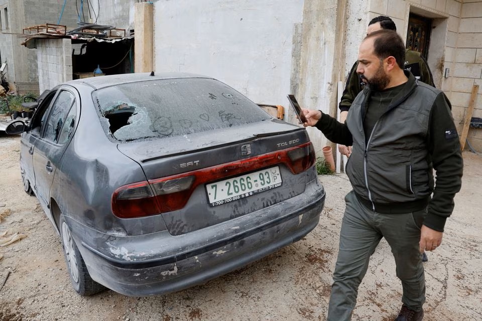 A Palestinian takes a picture of Omar Khalifa's car, which was attached by Israeli settlers while he was in it with his family, in Huwara, the Israeli-occupied West Bank. (Reuters) A Palestinian takes a picture of Omar Khalifa's car, which was attached by Israeli settlers while he was in it with his family, in Huwara, the Israeli-occupied West Bank. (Reuters)