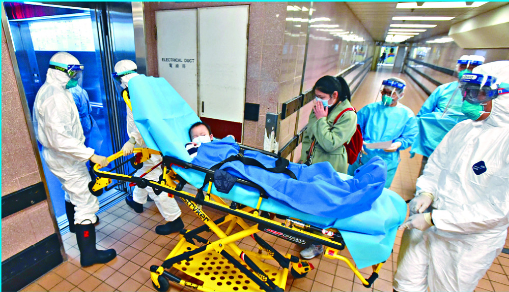 Staff in full protective gear take a child into Queen Elizabeth Hospital. Sing Tao Staff in full protective gear take a child into Queen Elizabeth Hospital. Sing Tao