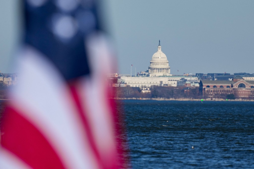 The U.S Capitol is seen in the background as a flag flies in Alexandria, Virginia, U.S., December 24, 2025. REUTERS/Ken Cedeno