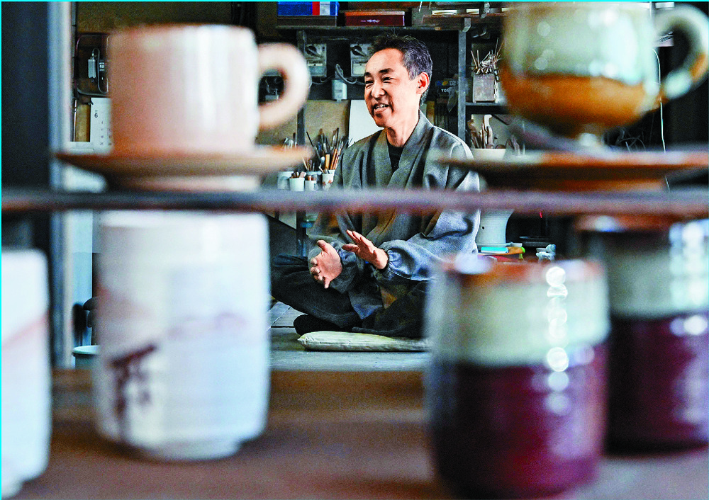 Potter Kosai Yamane, left, talks about how he uses the ash from burnt paper cranes from ceremonies, right, for glaze at  his pottery studio in Hatsukaichi. Below: a candle holder similar to the one given to Volodymyr Zelensky. 