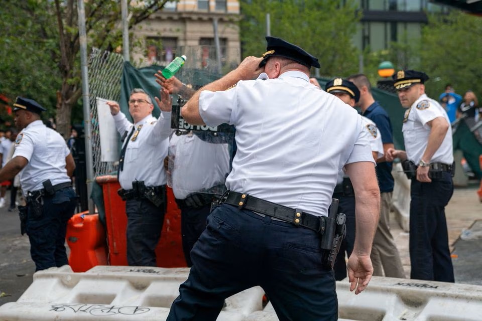 Police officers take cover from objects thrown by people as they respond to a 'giveaway' event announced by popular live streamer Kai Cenat that grew chaotic at Union Square and the surrounding streets in New York City, U.S. August 4, 2023. (Reuters) Police officers take cover from objects thrown by people as they respond to a 'giveaway' event announced by popular live streamer Kai Cenat that grew chaotic at Union Square and the surrounding streets in New York City, U.S. August 4, 2023. (Reuters)
