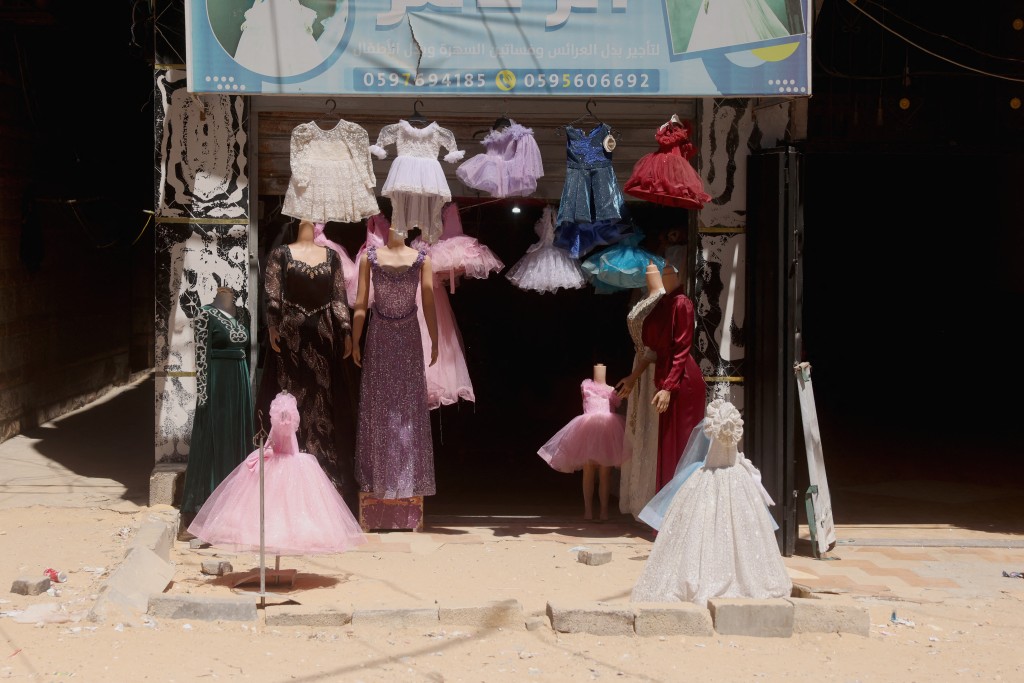 Photo by BASHAR TALEB / AFP Dresses worn for special occasions including weddings are on display outside a shop where they are created despite limited resources and old dresses are recycled, in the city of Khan Yunis in the southern Gaza Strip on June 13, 2026.