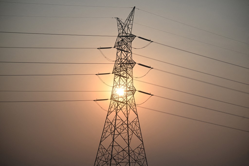 Photo by TED ALJIBE / AFP  This file photo taken on April 16, 2026 shows the sun setting next to power lines along San Fernando town, Pampanga province, north of Manila.