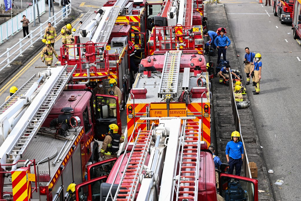 Photo by PETER PARKS / AFP  Firefighters prepare to enter the still burning Wang Fuk Court residential estate in Hong Kong's Tai Po district on November 27, 2025.