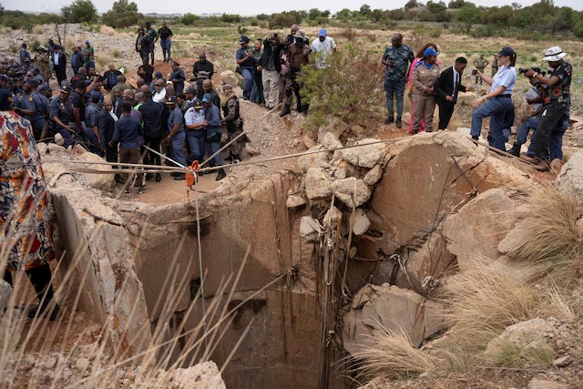 Community members watch as Senzo Mchunu, South African police minister, inspects outside the mineshaft where it is estimated that hundreds of illegal miners are believed to be hiding underground, after police cut off food and water as part of police operations against illegal miners, in Stilfontein, South Africa, November 15, 2024. REUTERS/Ihsaan Haffejee Community members watch as Senzo Mchunu, South African police minister, inspects outside the mineshaft where it is estimated that hundreds of illegal miners are believed to be hiding underground, after police cut off food and water as part of police operations against illegal miners, in Stilfontein, South Africa, November 15, 2024. REUTERS/Ihsaan Haffejee