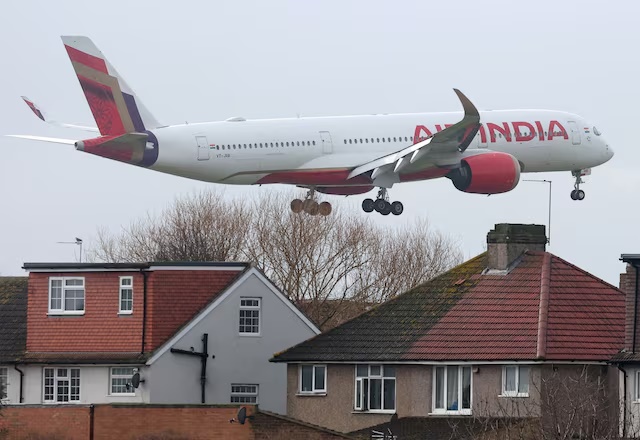 An Air India passenger plane flies near houses as it makes its landing approach to Heathrow Airport in west London, Britain, January 28, 2025. REUTERS/Toby Melville/File Photo