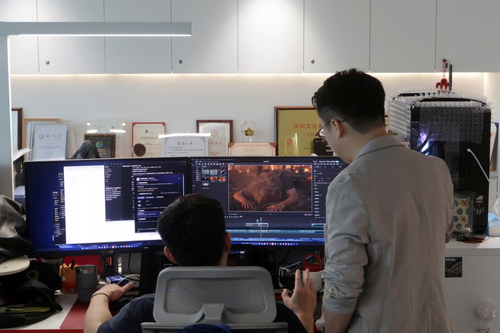 Zhu Zhili, a Chinese AI director, discusses an AI-generated video with a colleague at the office of China Wit Media, a film and television production company, in Shenzhen, Guangdong province, China August 17, 2026. REUTERS/Ellen Zhang