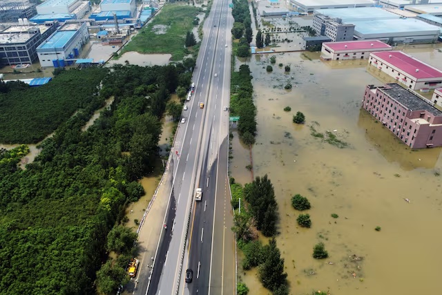 An aerial view shows flooded industrial buildings by a highway following heavy rainfall in Xinxiang, Henan province, China July 24, 2021. Picture taken with a drone. REUTERS/Aly Song/File Photo 