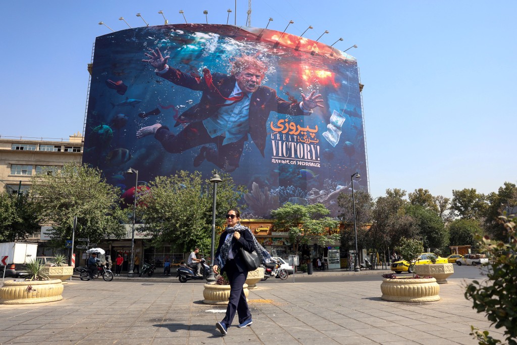 A woman walks past an anti-US billboard in Tehran on August 24, 2026.