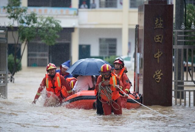 FILE PHOTO: Rescue workers evacuate with an inflatable boat students stranded by floodwaters at a school, amid heavy rainfall in Duchang county, Jiangxi province, China July 8, 2020. China Daily via REUTERS