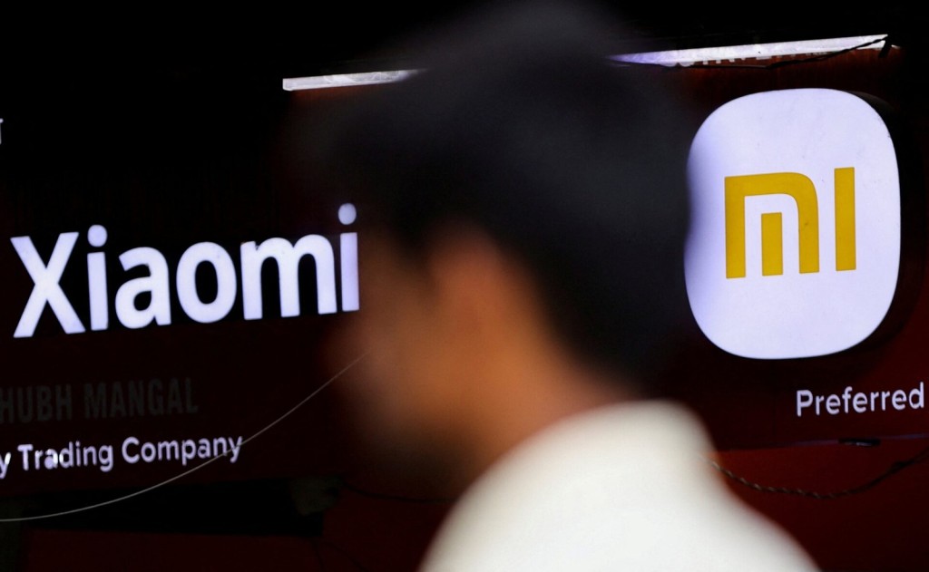 A man walks past the logo of Chinese smartphone maker Xiaomi outside a shop in Mumbai, India, May 11, 2022. REUTERS