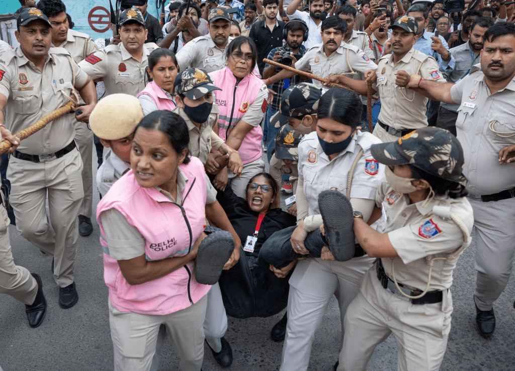 Security personnel and police detain a journalist during a protest by the Cockroach Janta Party (CJP) seeking the resignation of India's Chief Election Commissioner Gyanesh Kumar, near the protest site in New Delhi, India, October 11, 2026. REUTERS/Adnan Abidi