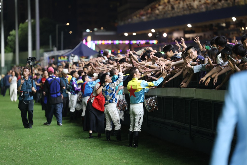 Jockeys hand out souvenirs with a full house of racegoers. (Sing Tao)