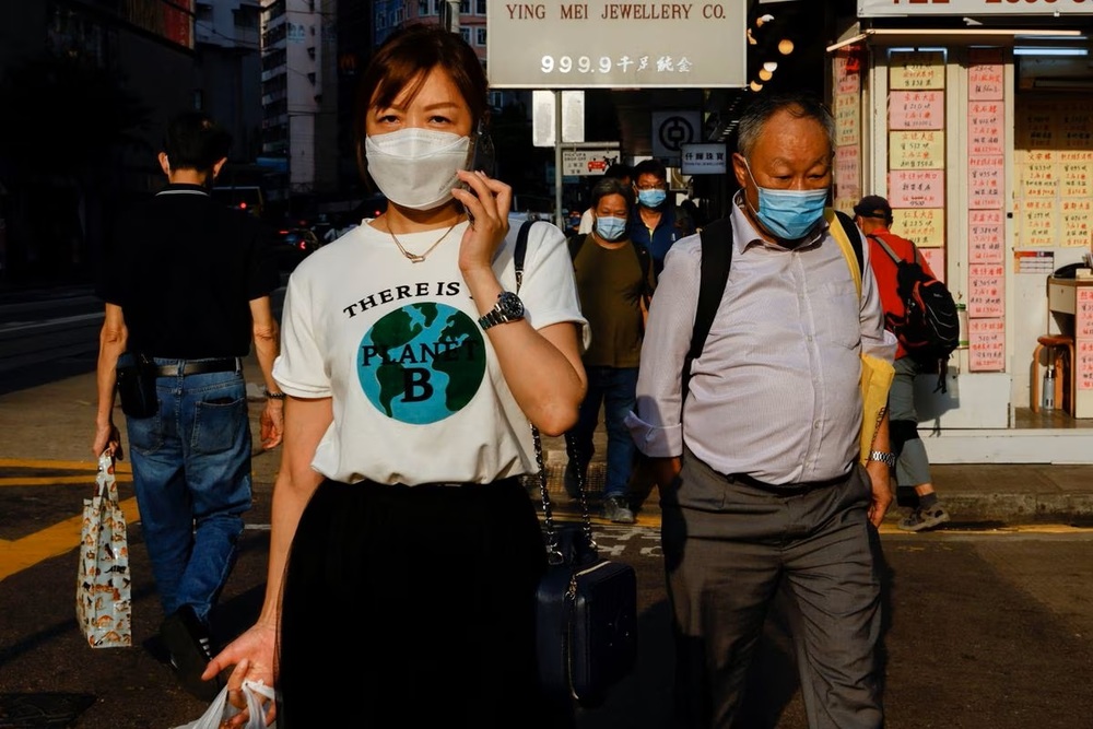People wearing face masks walk through Wan Chai during the coronavirus disease (Covid-19) pandemic in Hong Kong. People wearing face masks walk through Wan Chai during the coronavirus disease (Covid-19) pandemic in Hong Kong.