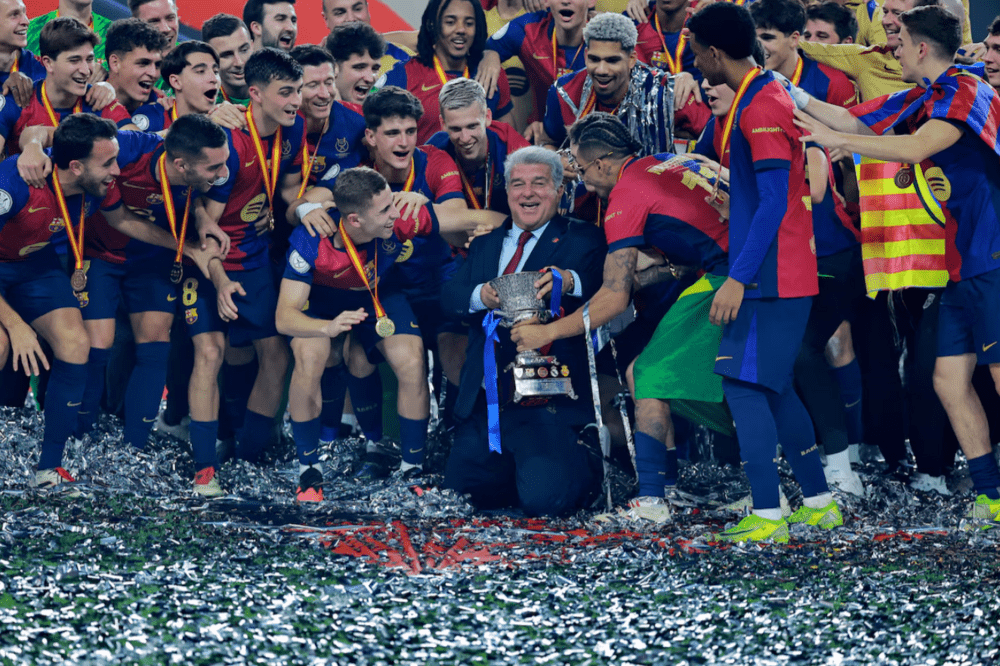 FC Barcelona president Joan Laporta celebrates with the trophy and players after winning the Spanish Super Cup. (REUTERS/Stringer)