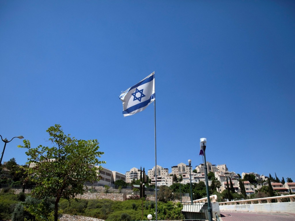 The Israeli national flag flutters as apartments are seen in the background in the Israeli settlement of Maale Adumim in the Israeli-occupied West Bank August 16, 2020. Picture taken August 16, 2020. REUTERS/Ronen Zvulun/File Photo