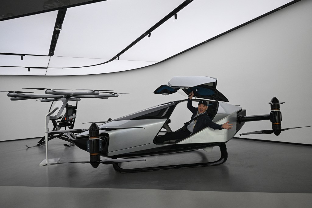 A journalist sits in Xpeng's flying car Traveller X2 during a showroom tour in Guangzhou. (AFP)